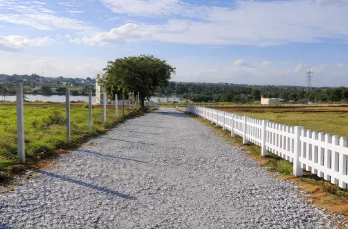 scenic view and internal road with picket fencing and trees at Lakeview Farmland Denkanikottai