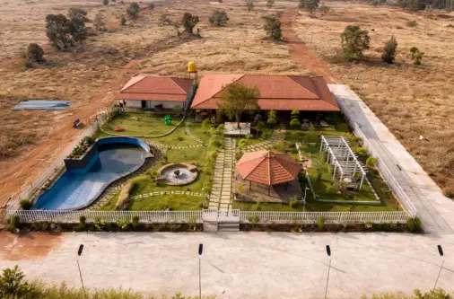 Farmhouse amenities and clubhouse with pool and garden in farmland project for sale near Hoskote